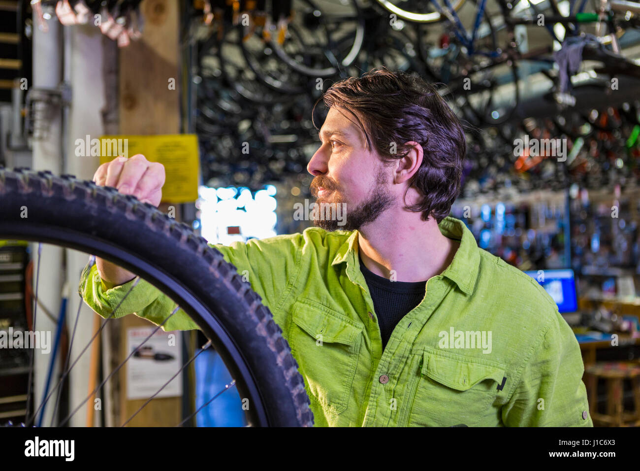 Kaukasische Arbeiter Reparatur Fahrrad-Rad im shop Stockfoto