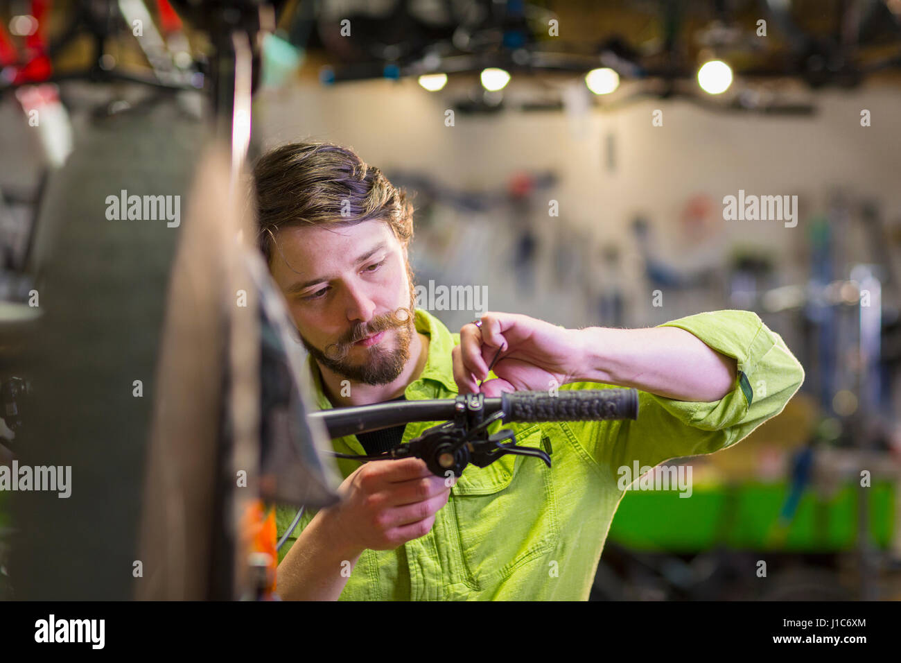 Kaukasische Arbeiter Reparatur Fahrradlenker im shop Stockfoto
