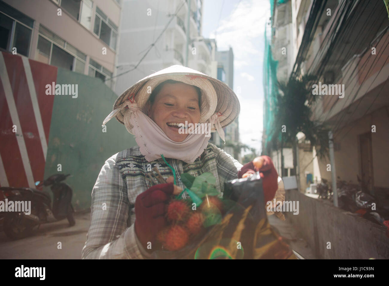Vietnamesische Frau lächelnd in Straße Stockfoto