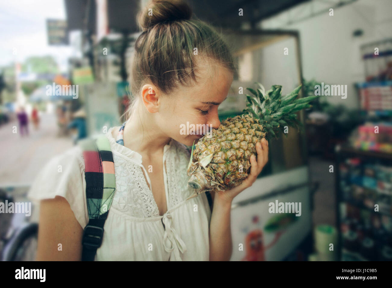Kaukasische Frau riecht Ananas am Markt Stockfoto