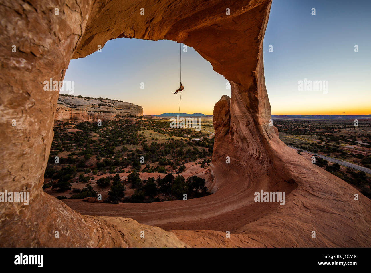 Eric Odenthal Abseilen aus Wilson Arch in der Nähe von Moab, Utah. Stockfoto