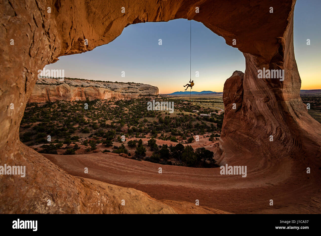 Eric Odenthal Abseilen aus Wilson Arch in der Nähe von Moab, Utah. Stockfoto