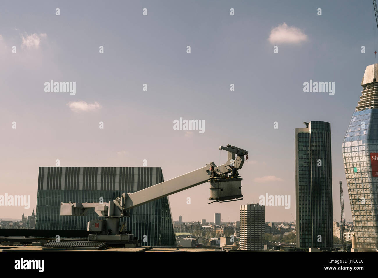 Zwei Fensterreiniger arbeitet an einer Docking-Station hoch über der Skyline von London Stockfoto