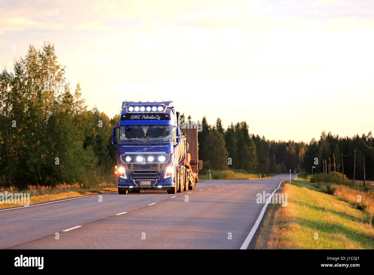SALO, Finnland - 9. September 2016: Blau Volvo FH16 750 Kung Fu Panda LKW für den Bau mit hellen Lichtern auf szenische Landstraße in Abend du anzeigen Stockfoto
