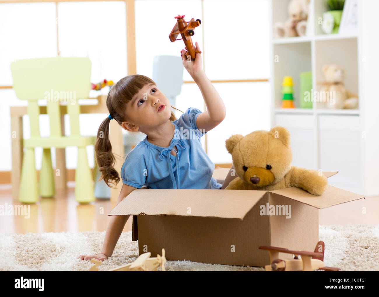 Kind spielt mit dem Flugzeug Spielzeug zu Hause. Reisen, Freiheit und Phantasie Konzept. Stockfoto