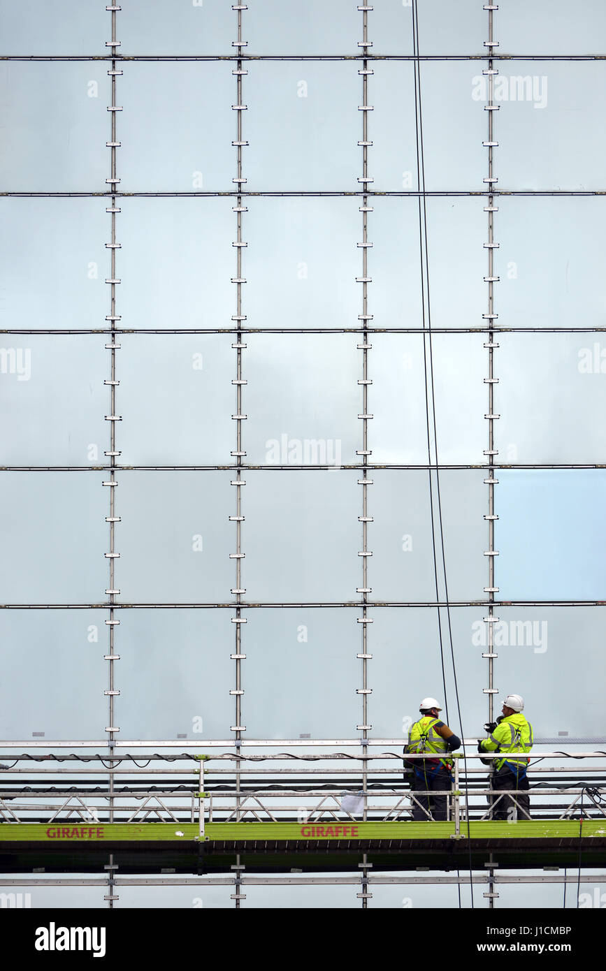 Arbeiter auf einer Plattform Reparatur Glas fronted Gebäude Stockfoto