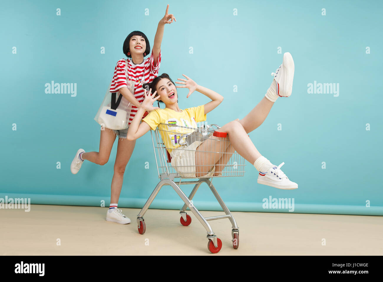 Glücklich Mode Schwestern schieben Einkaufswagen Stockfoto