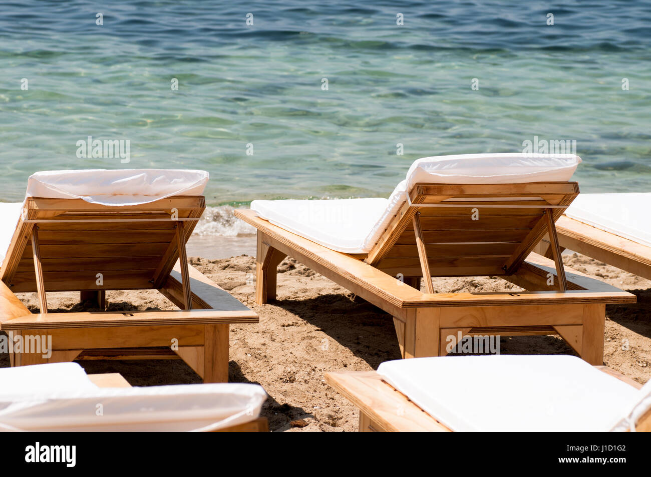 Liegestühle am Strand in der Nähe des Meeres Stockfoto