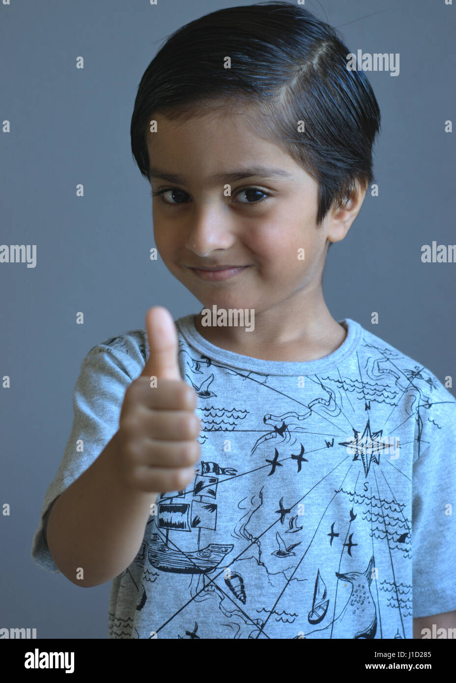 Glückliches Kind tun, Daumen nach oben. Lächelnd Kind zeigt positive Haltung Stockfoto