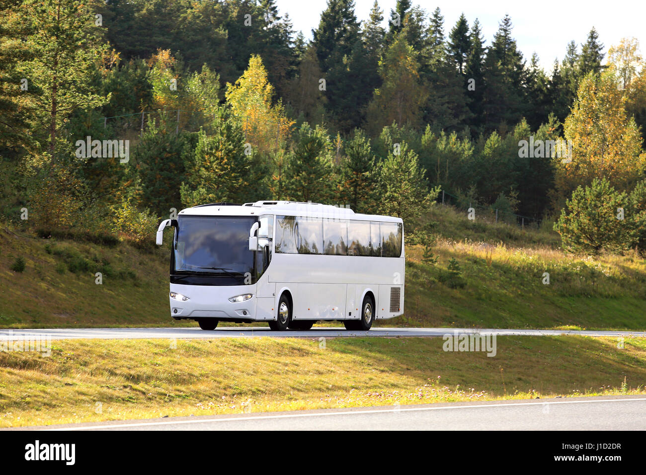 Weiße Reisebus fährt auf Autobahn mit Herbstlaub auf dem Hintergrund. Platz für Ihren Text zu kopieren. Stockfoto
