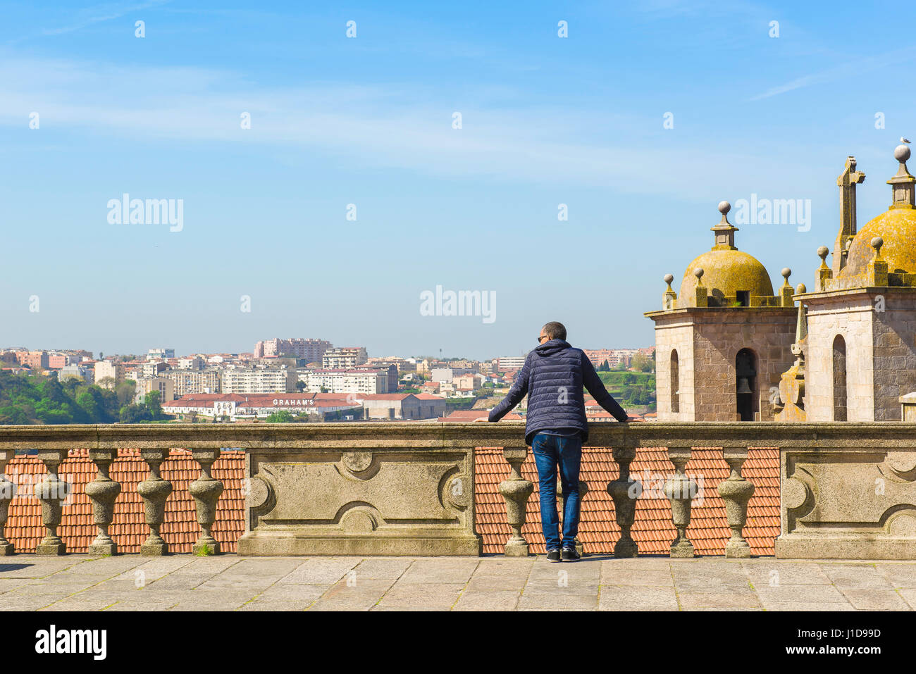 Ein Mann steht allein auf der Terrasse der Kathedrale in Porto, Portugal, Blick über die Dächer der Altstadt im Zentrum der Stadt. Stockfoto