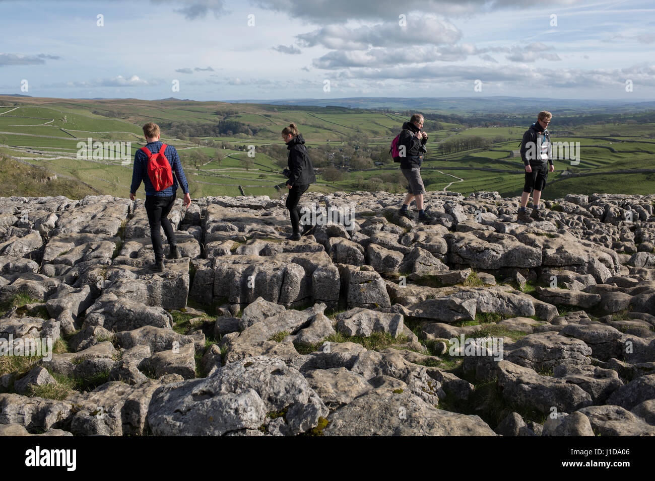 Wanderer weitergeben über den Kalkstein Pflaster bei Ing Narbe in der Nähe von Malham in der Yorkshire Dales National Park, 12. April 2017, in Malham, Yorkshire, Großbritannien Stockfoto