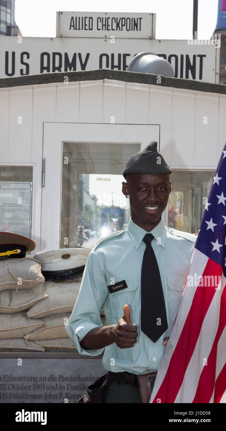 BERLIN, Deutschland - 23. Mai: Mann gekleidet wie ein US-Army Soldat mit einer amerikanischen Flagge am ehemaligen Alliierten Checkpoint "Charlie" steht am 23. Mai 2014. Jetzt Stockfoto