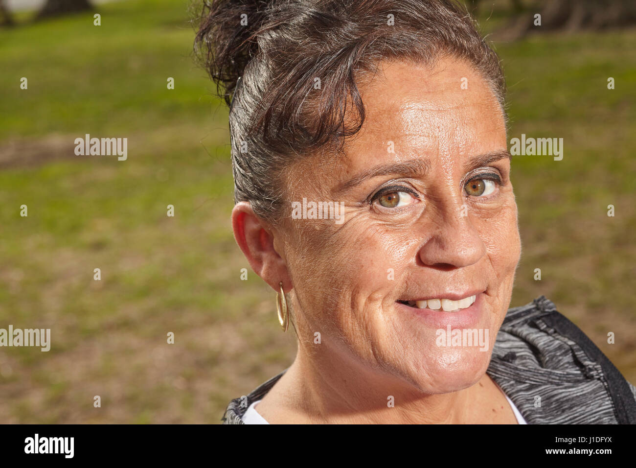 Eine Frau in den Fünfzigern mit einem nachdenklichen Lächeln Stockfoto