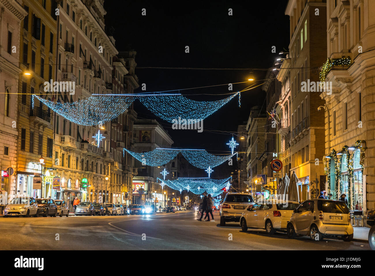 Rom, Italien - 3. Januar 2017: Weihnachtsbeleuchtung auf einer Straße in der Nacht mit Passanten in Rom, Italien Stockfoto