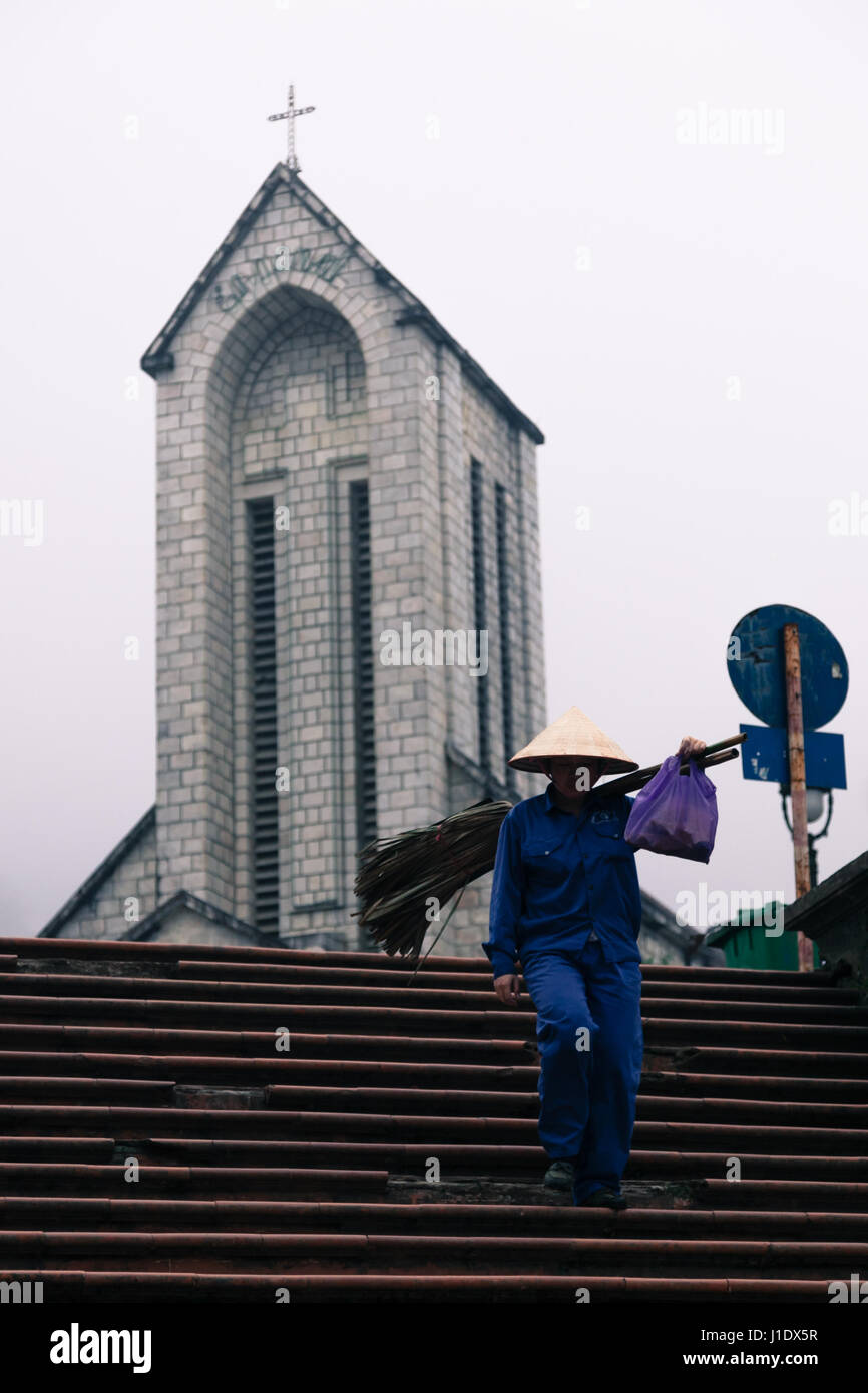 Ein Bauer läuft hinunter die Schritte außerhalb der Steinkirche in Sa Pa (Sapa), Nord-Vietnam, Südostasien Stockfoto