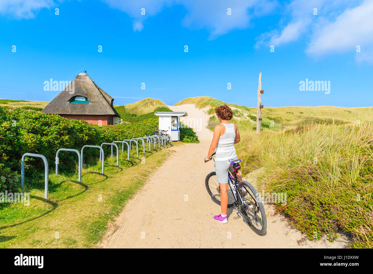 Insel SYLT, Deutschland - SEP 6, 2016: junge Frau auf einem Fahrrad während der Fahrt entlang der Küste von Sylt Insel, Deutschland. Stockfoto