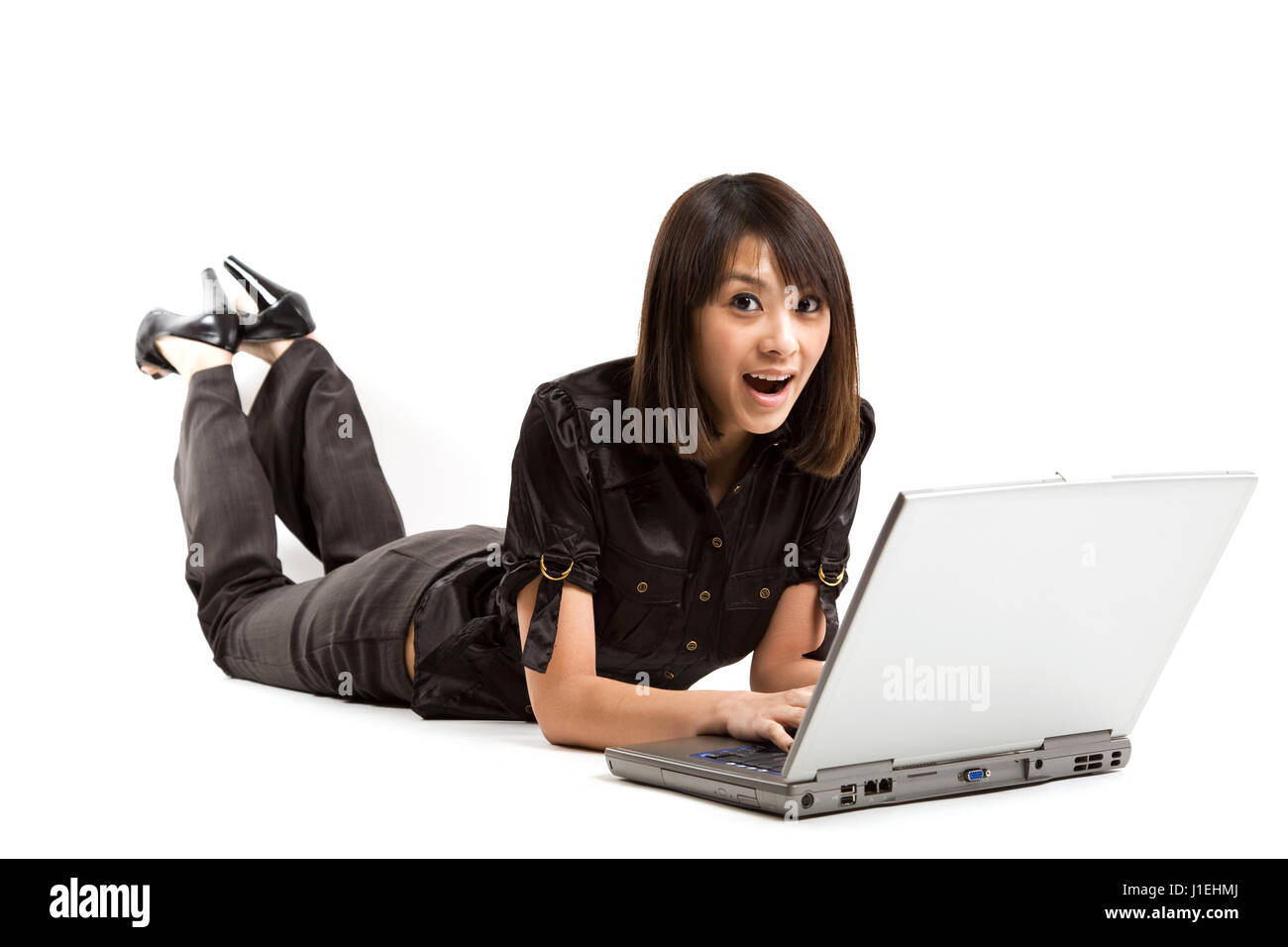 Eine schöne Frau, die Arbeit an ihrem Laptop mit einen überraschten Blick Stockfoto