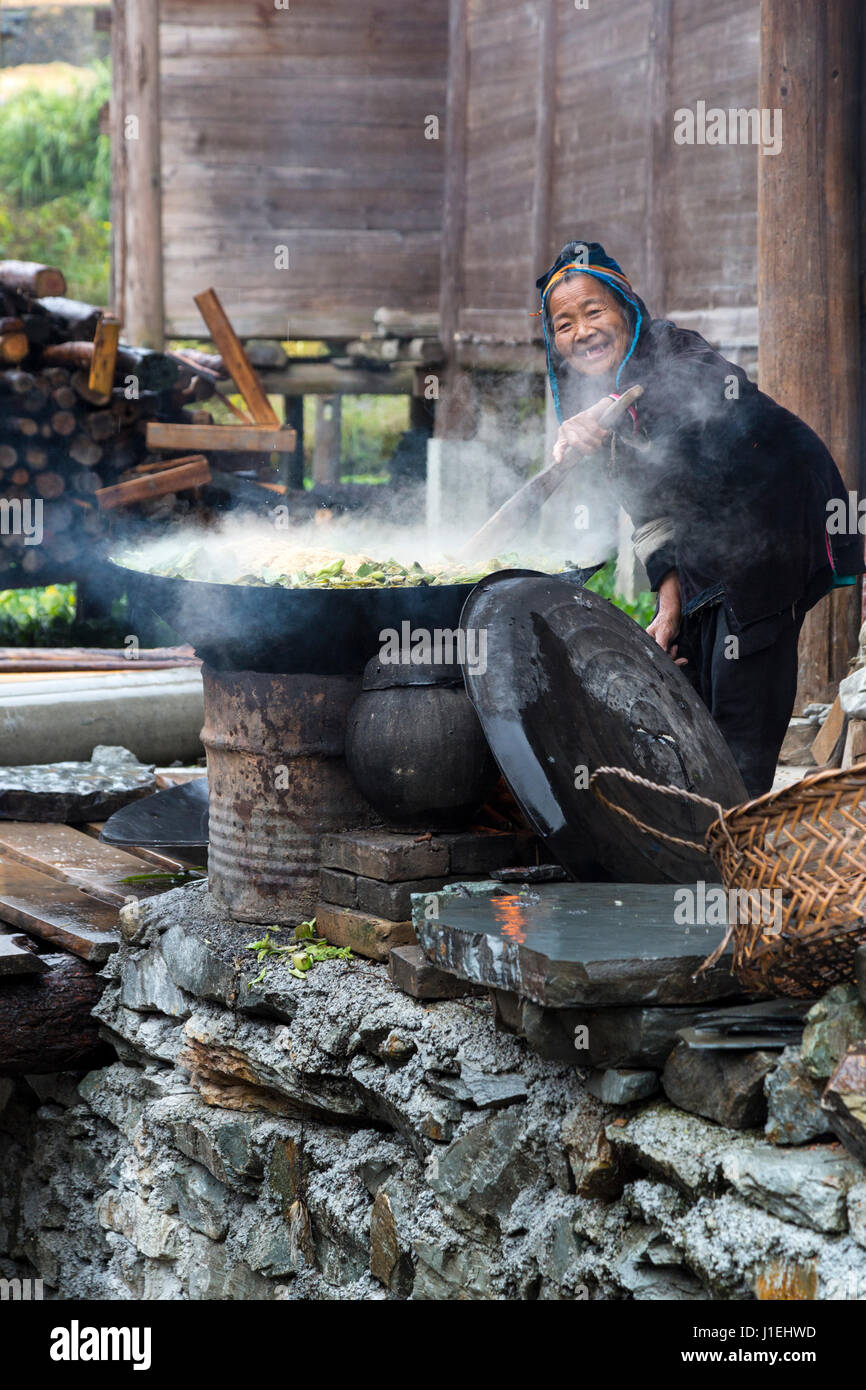 Huanggang, Guizhou, China.  Dong-Frauen Grüns für Schwein Essen kochen. Stockfoto