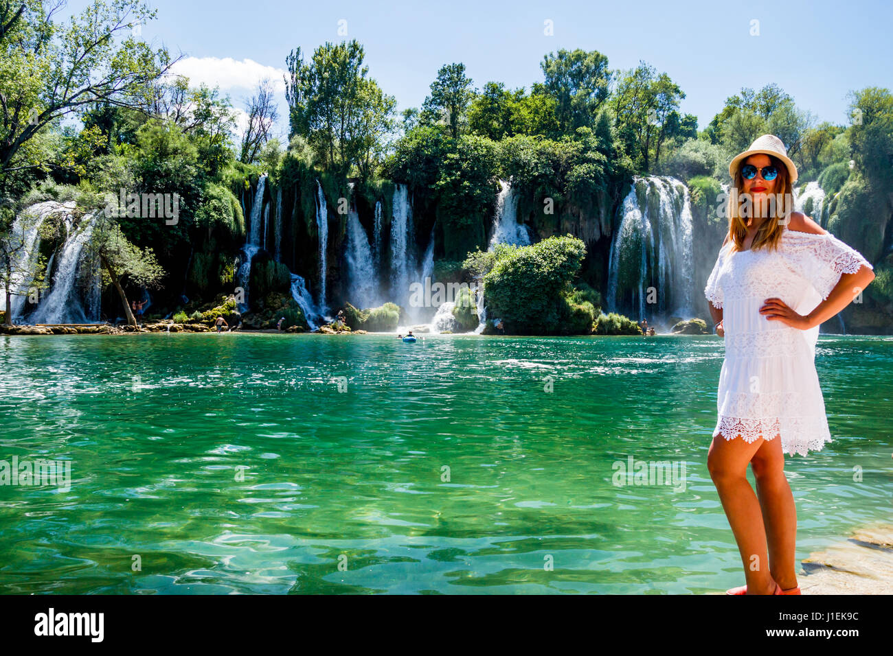 Mädchen im weißen Kleid in der Nähe von Kravice Wasserfall Bosnien Stockfoto