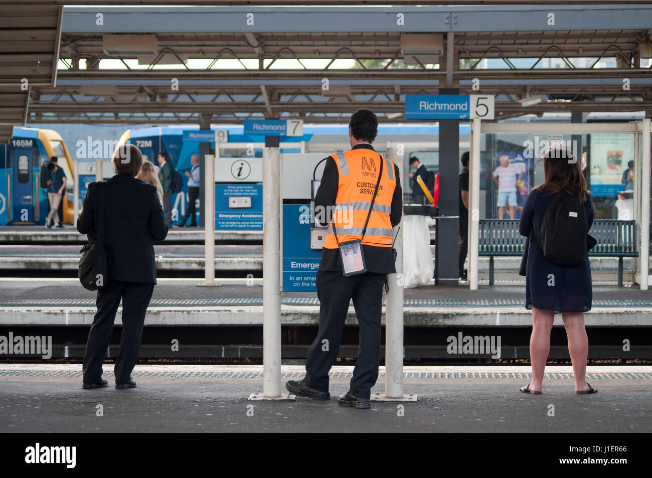 Bahn-Mitarbeiter und Pendler auf einer Plattform in Richmond Station, Melbourne, Australien Stockfoto
