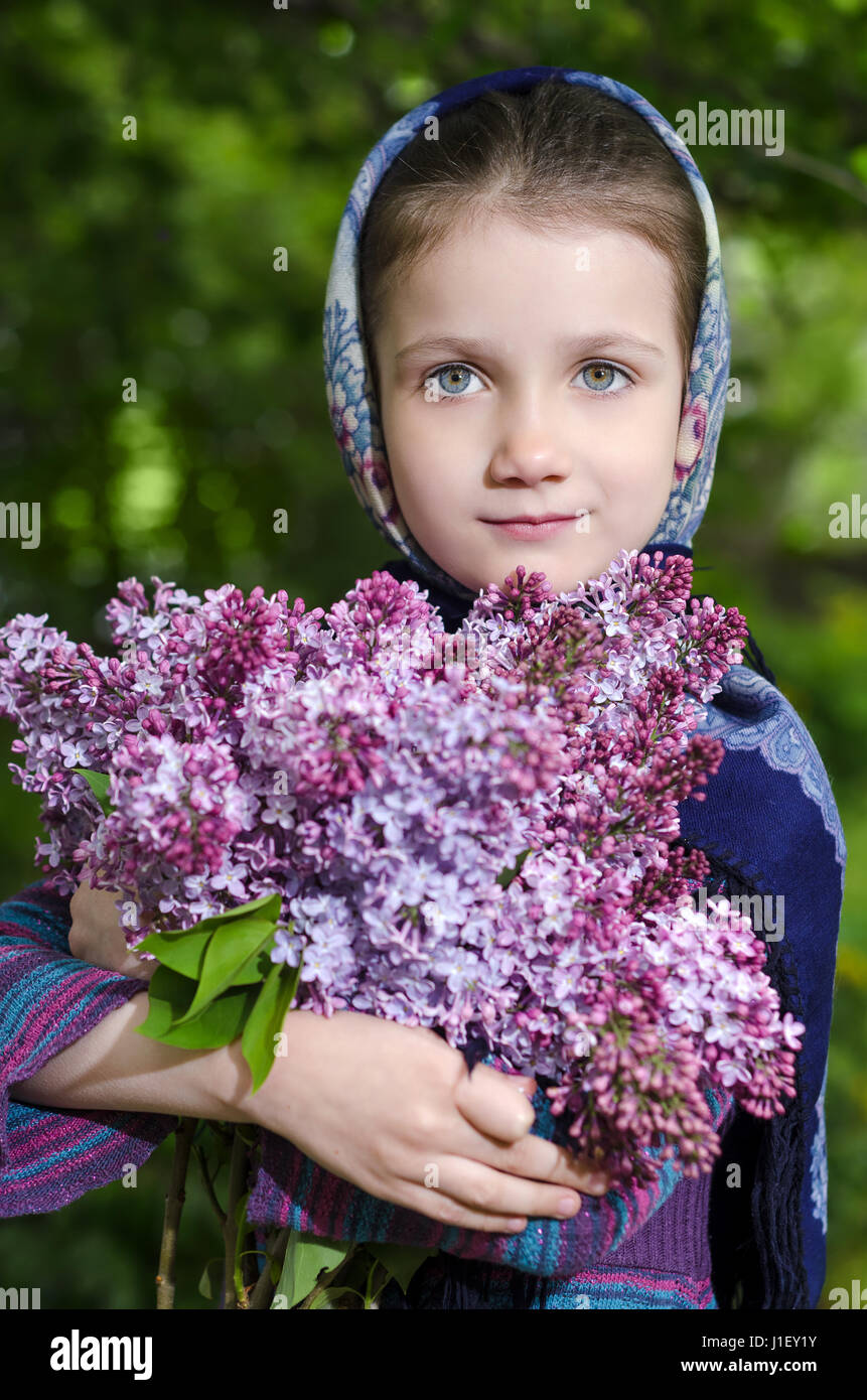 Kleines Mädchen mit einem Bouquet von einer blühenden Flieder in der hand Stockfoto