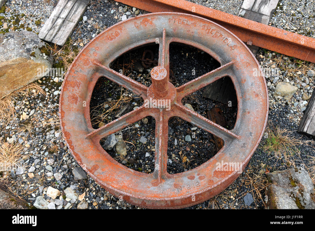 In SheffieVild gemacht - ein Stahlseil Rad liegt als atrefacts auf der Denniston Meine historischen Ort in der Nähe von Westport, Südinsel Neuseeland. Stockfoto