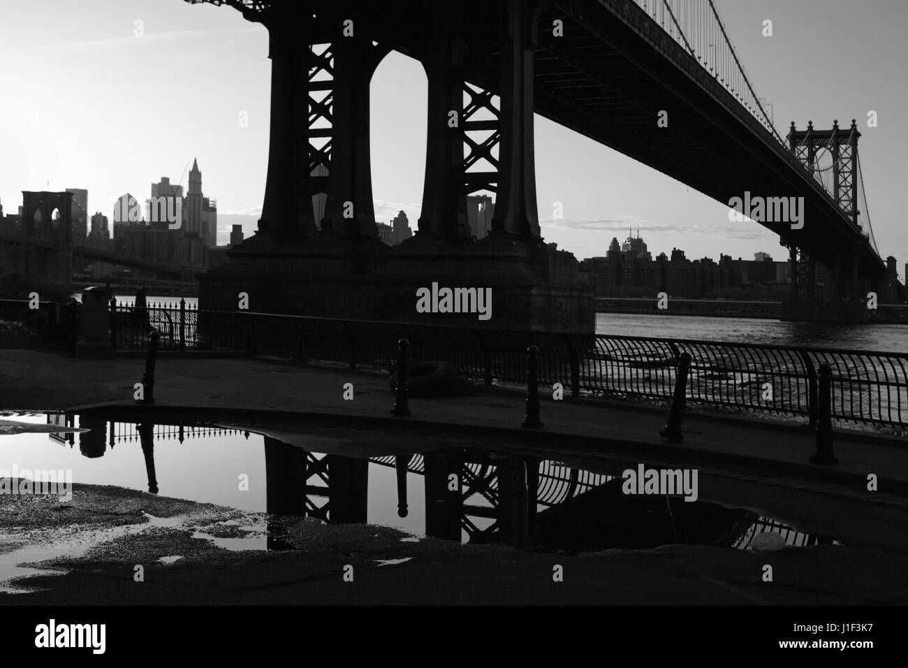 Einbruch der Dunkelheit in DUMBO Brooklyn, New York bei Sonnenuntergang unter der Manhattan Bridge. Monochrom, schwarz und weiß. Stockfoto