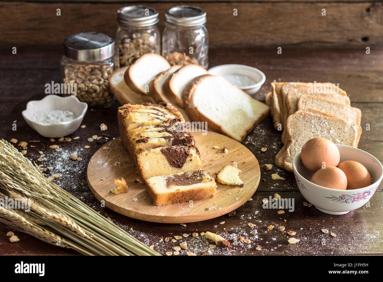 Marmor-Schokoladenkuchen auf Schneidebrett mit Brot und Zutat in der Küche Stockfoto