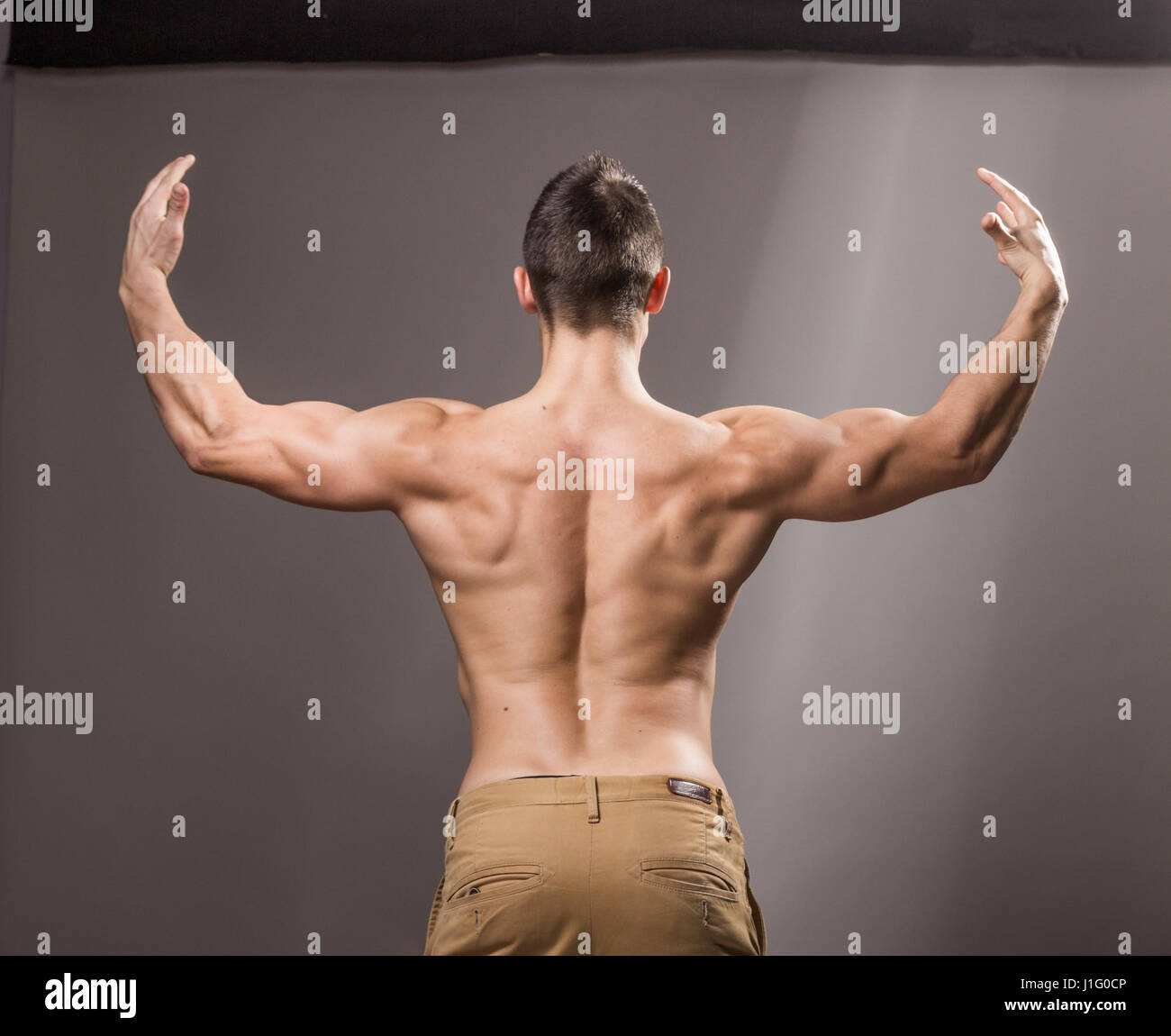 Sicht nach hinten, Rücken Muskeln Bodybuilder, jungen Erwachsenen Mann posiert, Arme Hände ausgestreckt, weite Stockfoto