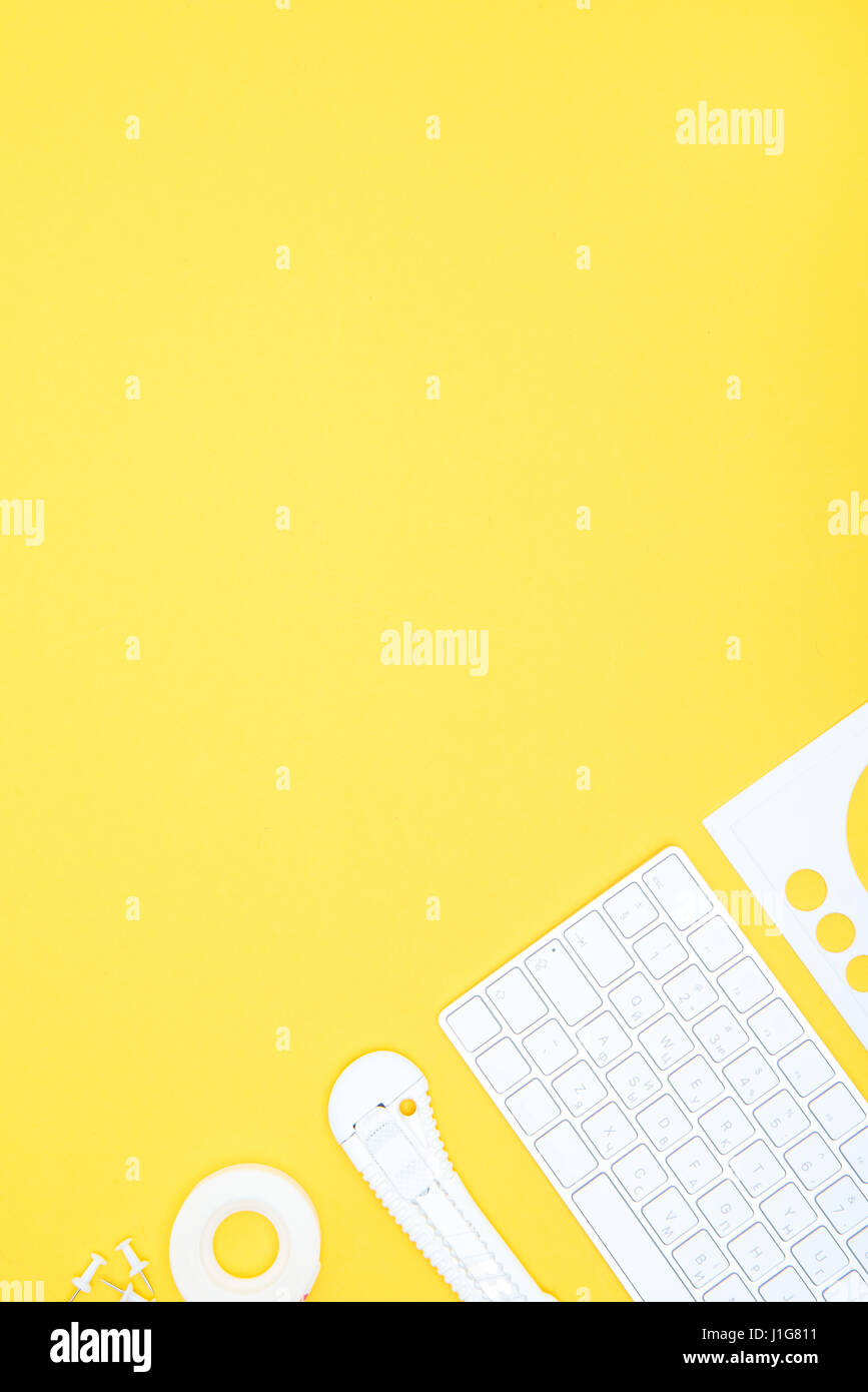 Flache Lay von Büromaterial, Tastatur und Schreibwaren Messer mit textfreiraum auf gelb Stockfoto