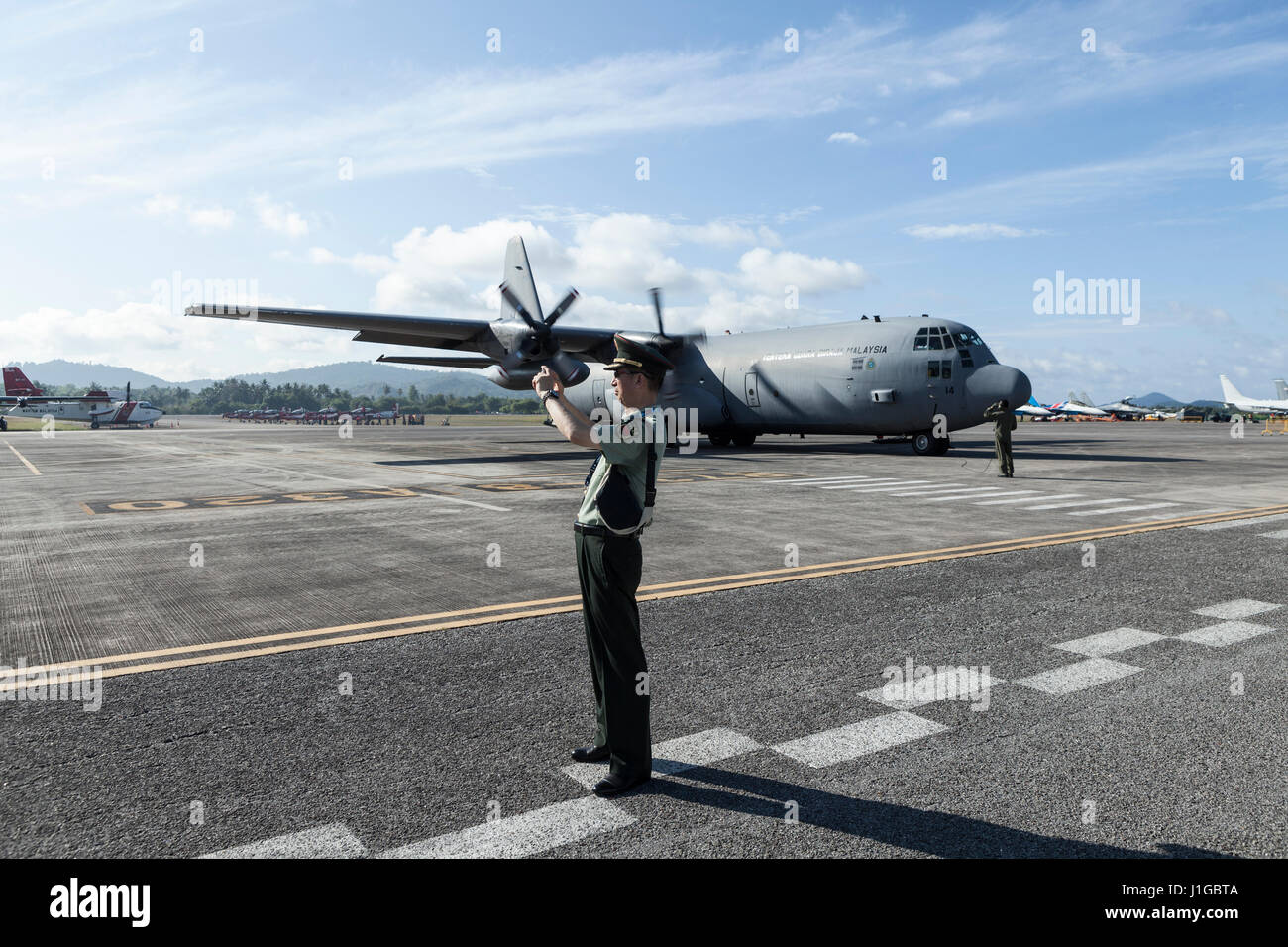 Eine chinesische Luftwaffe Offizier vor einer Royal Malaysian Air Force Lockheed C-130 Hercules auf Langkawi International Maritime und Luft-und Raumfahrt (LIMA) Ausstellung 2017 Stockfoto