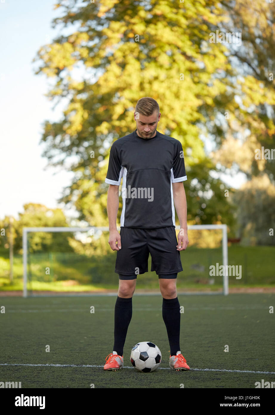 Fußballspieler mit Ball auf Fußballplatz spielen Stockfoto