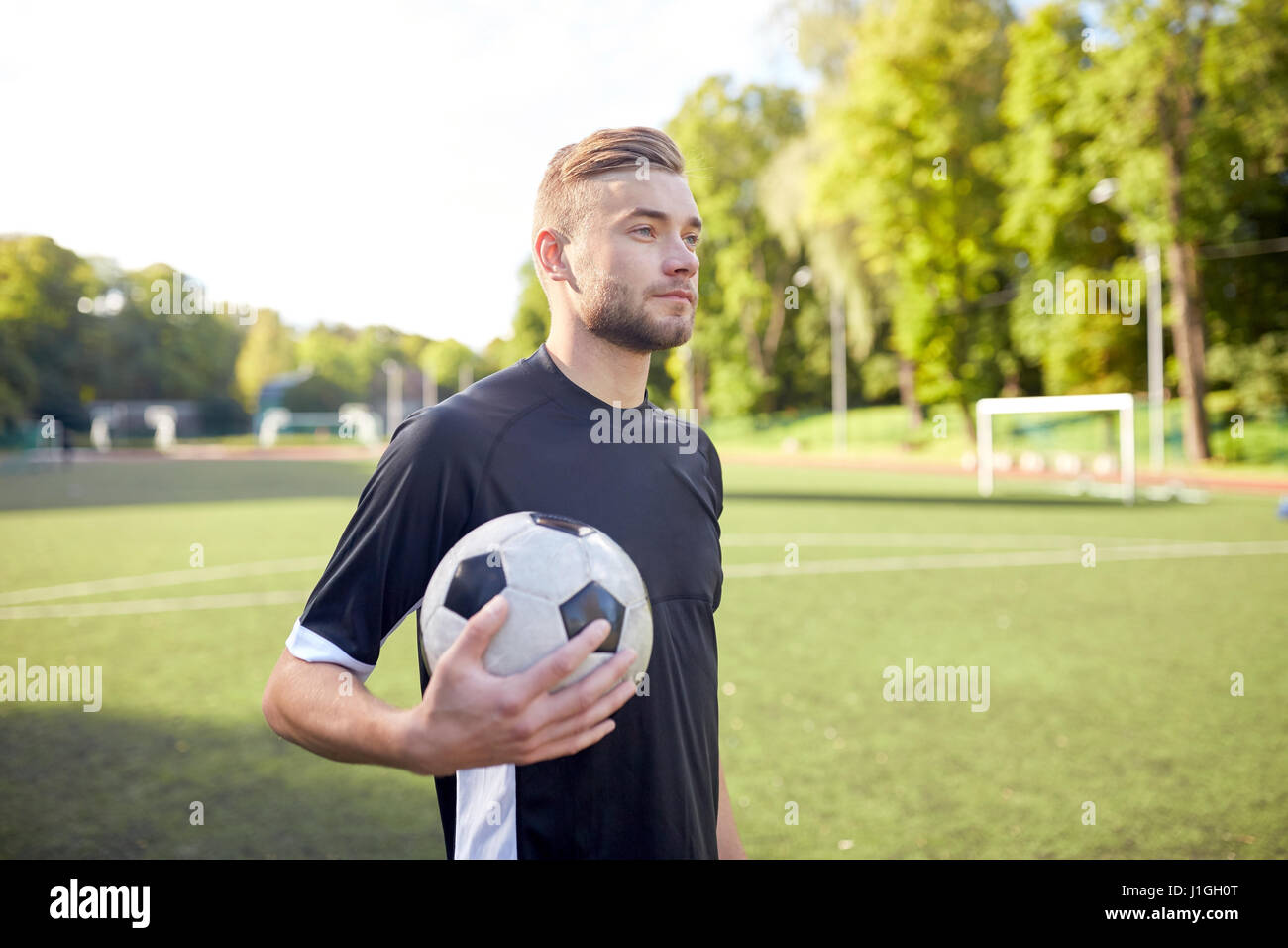 Fußballspieler mit Ball auf Fußballplatz Stockfoto