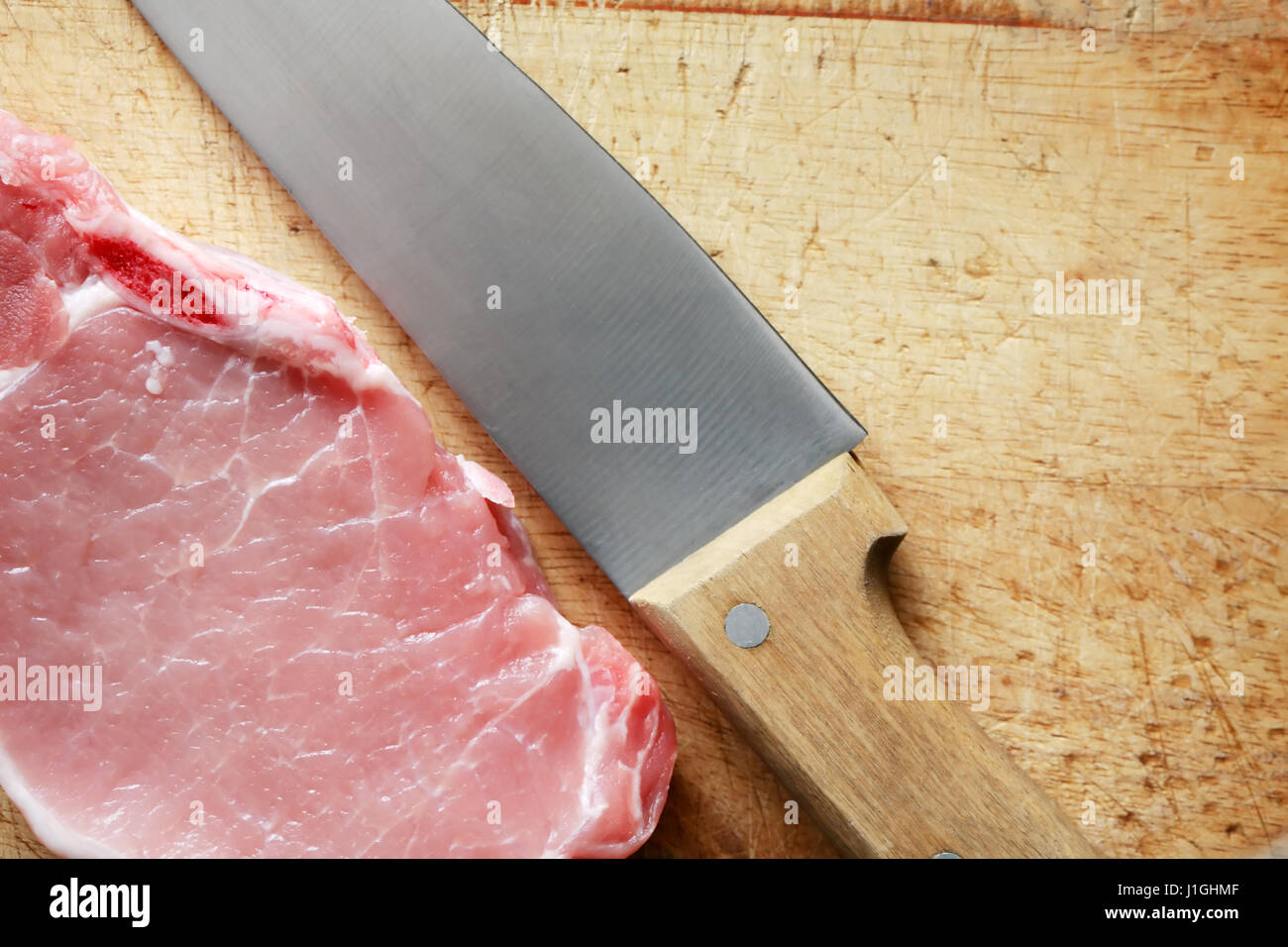Frische Stück rohes Fleisch in der Nähe von Messer auf Holzbrett Stockfoto