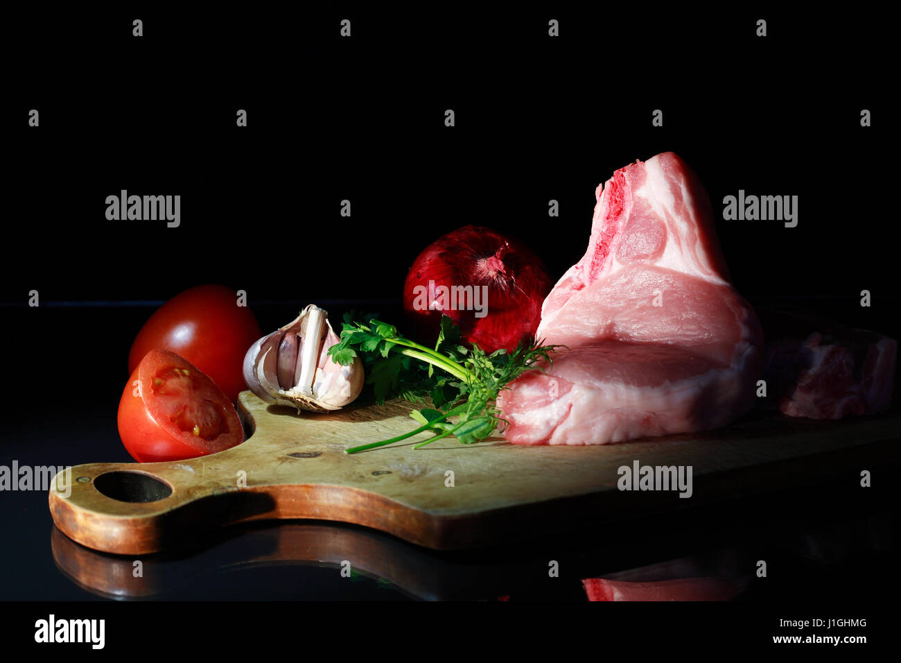 Frische Stück rohes Fleisch in der Nähe von Gemüse auf Holzbrett Stockfoto
