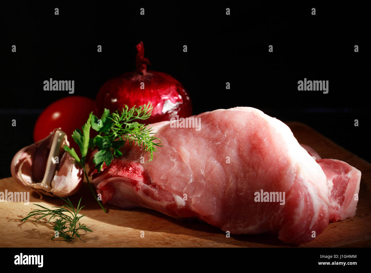 Frische Stück rohes Fleisch in der Nähe von Gemüse auf Holzbrett Stockfoto