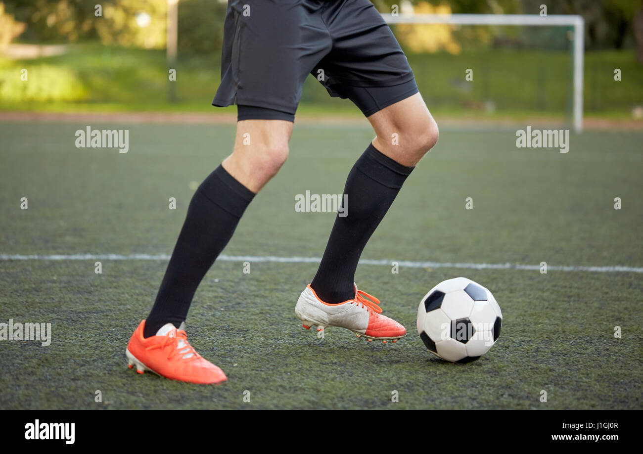 Fußballspieler mit Ball auf Fußballplatz spielen Stockfoto