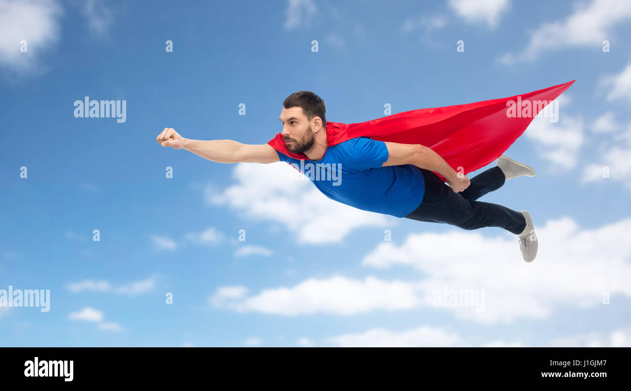 Mann in rote Superheld Kap über blauen Himmel fliegen Stockfoto
