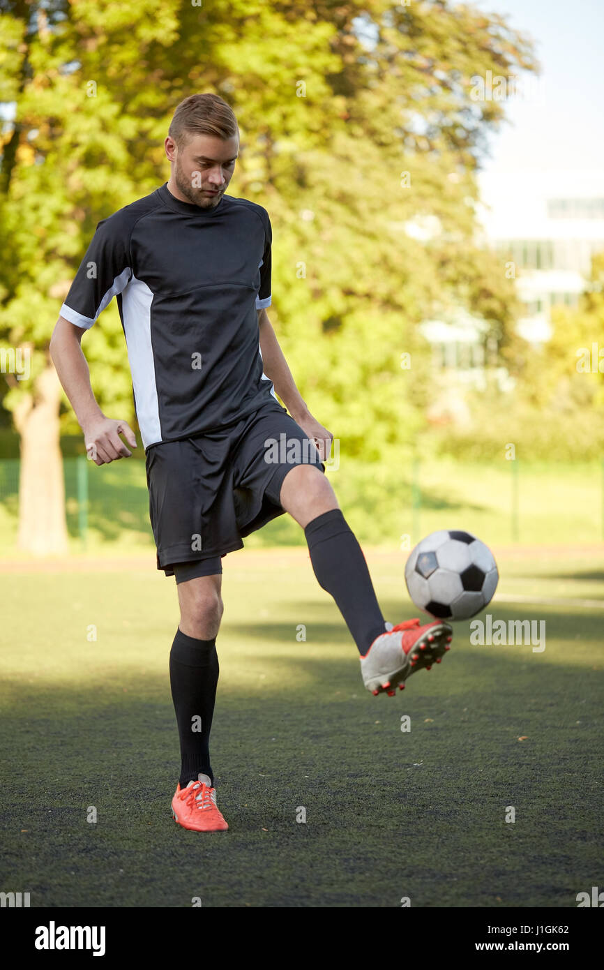 Fußball-Spieler spielen mit Ball auf Feld Stockfoto