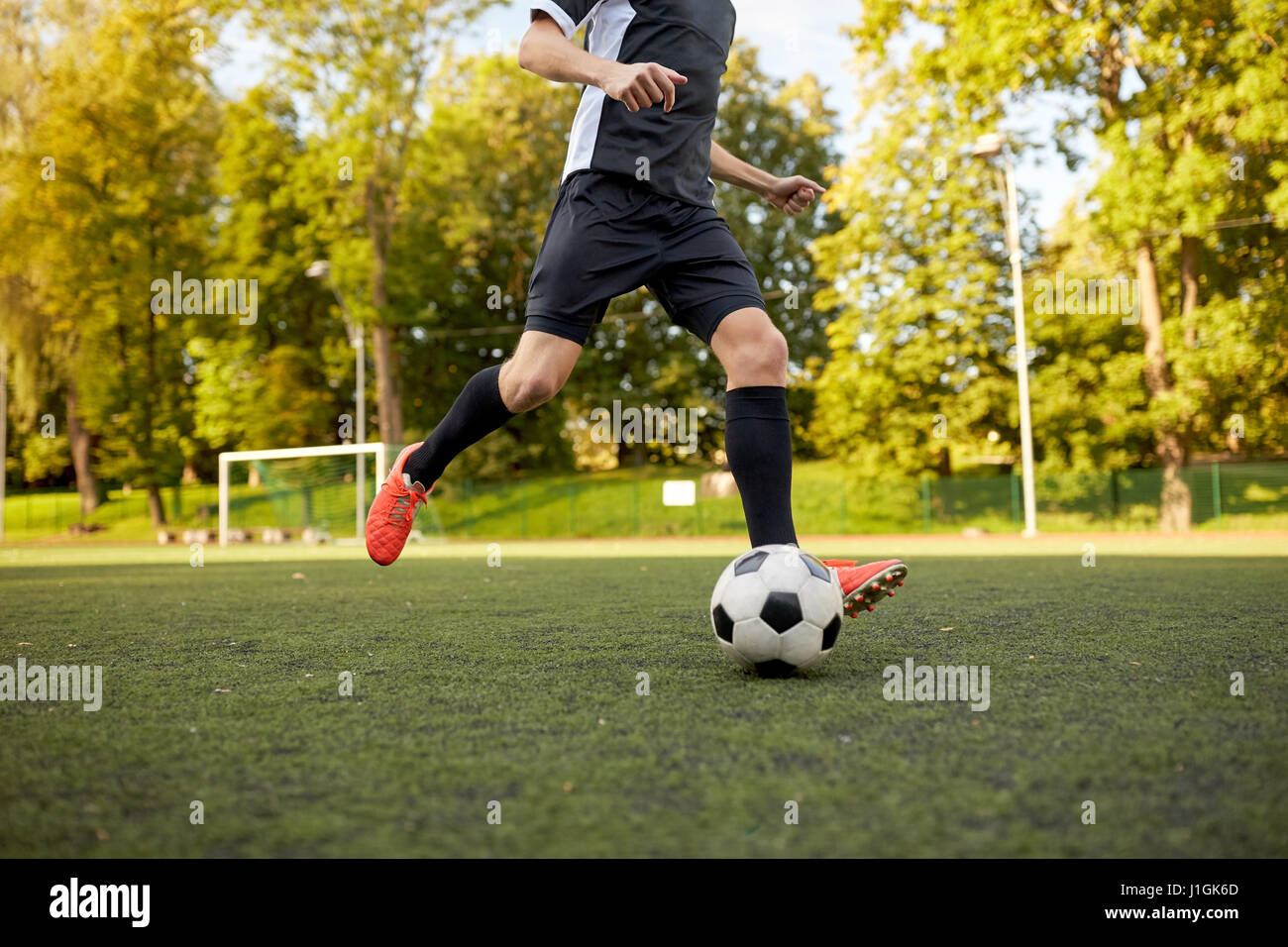 Fußballspieler mit Ball auf Fußballplatz spielen Stockfoto