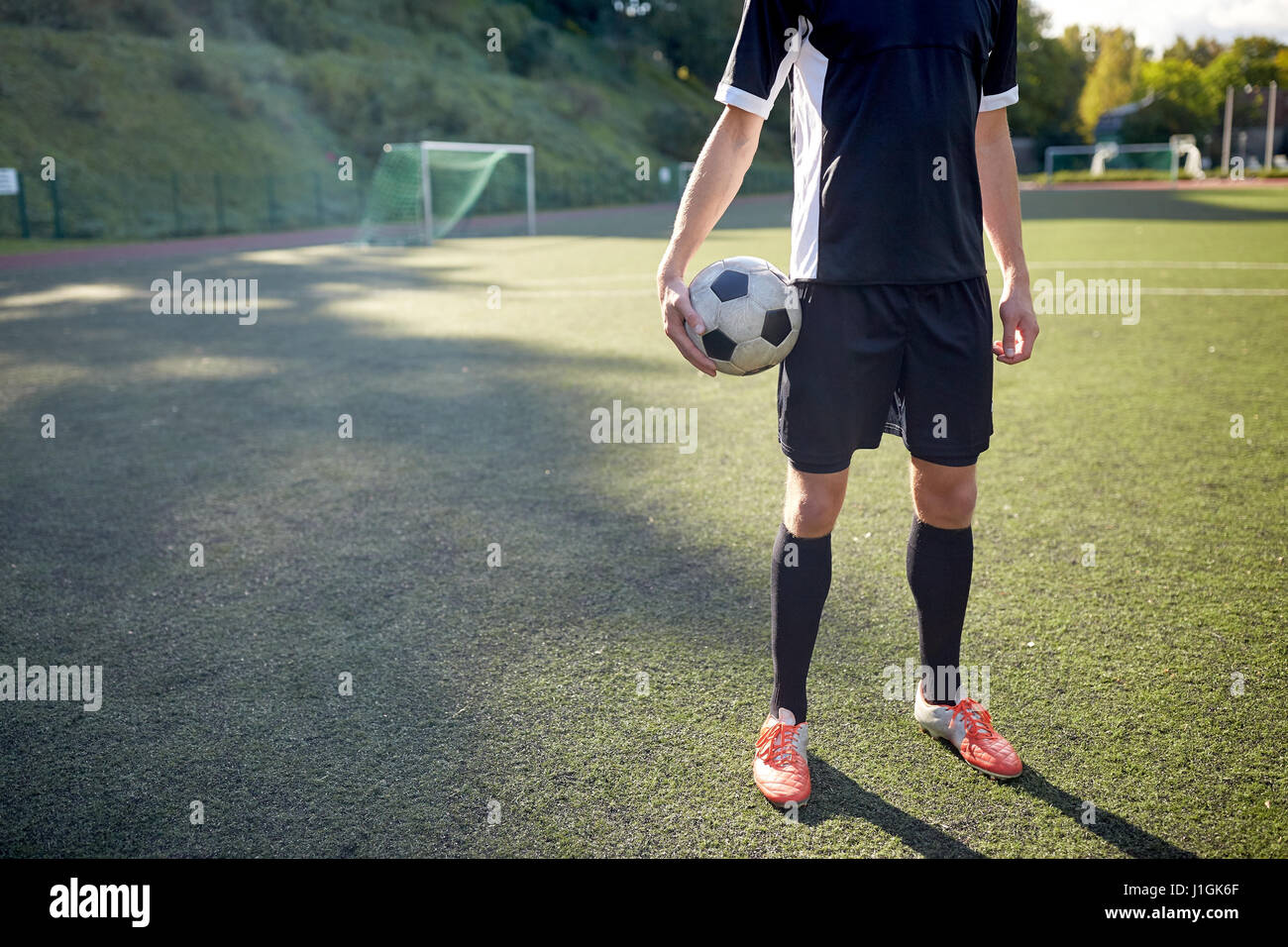 Fußballspieler mit Ball auf Fußballplatz Stockfoto