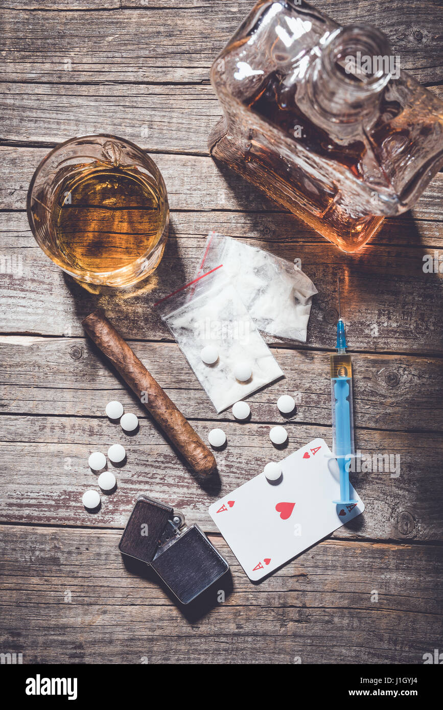 Harte Drogen und Alkohol auf einem alten Holztisch. Nahaufnahme Stockfoto