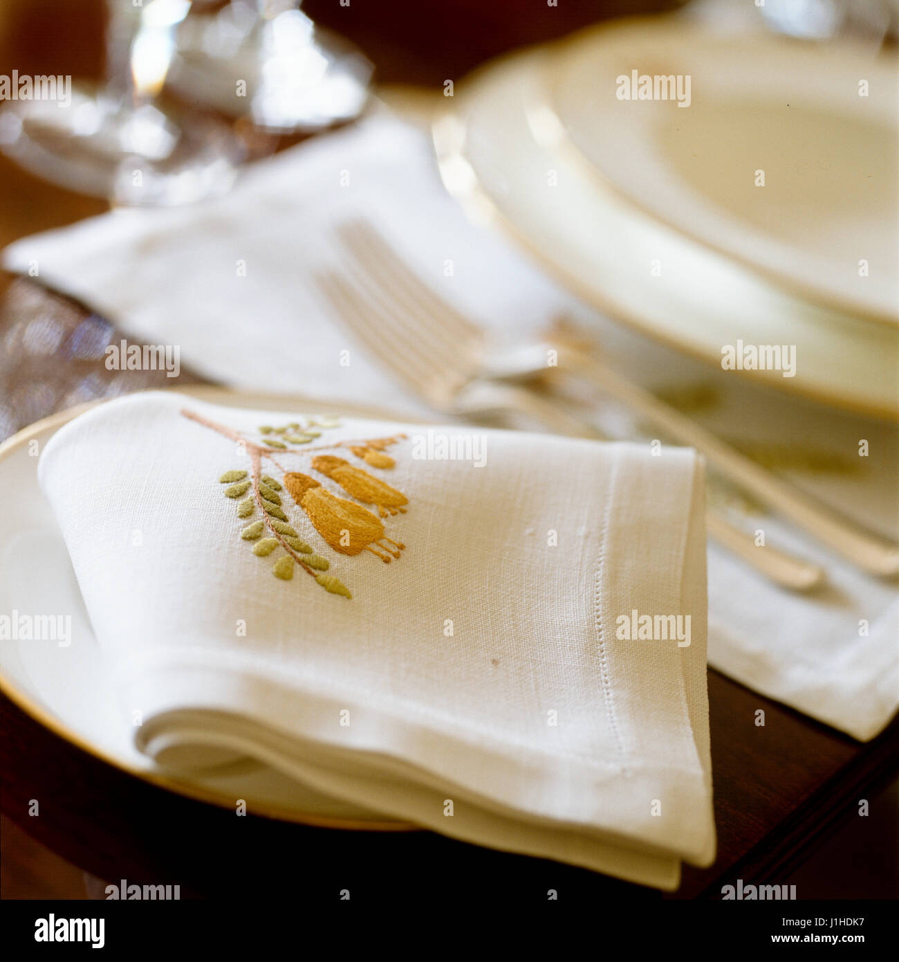 Weiße Tischgedeck mit bestickten Serviette. Stockfoto