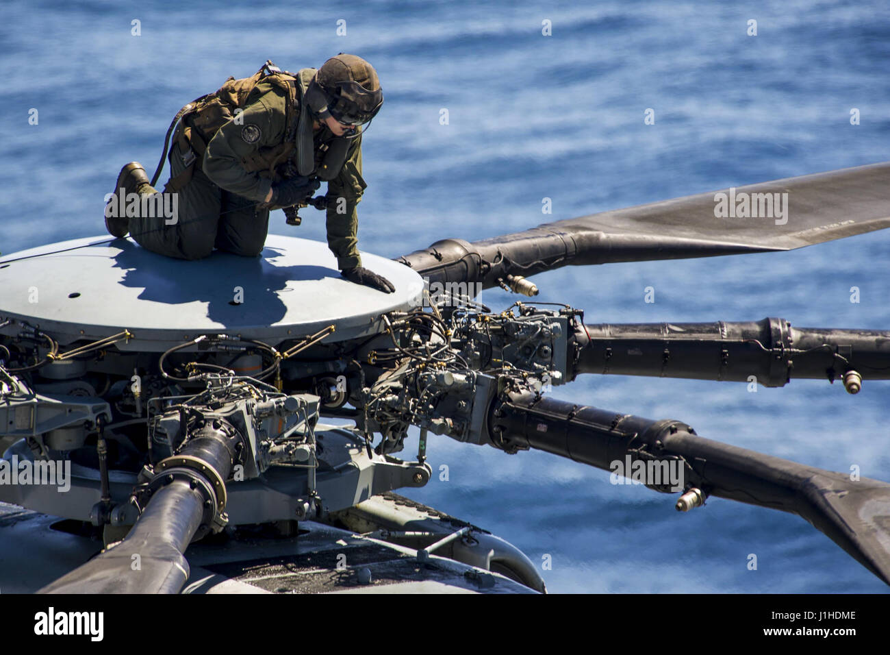 Eine Marine klettert an die Spitze der ein CH-53E Super Stallion, Wartung im Flugbetrieb durchzuführen Stockfoto