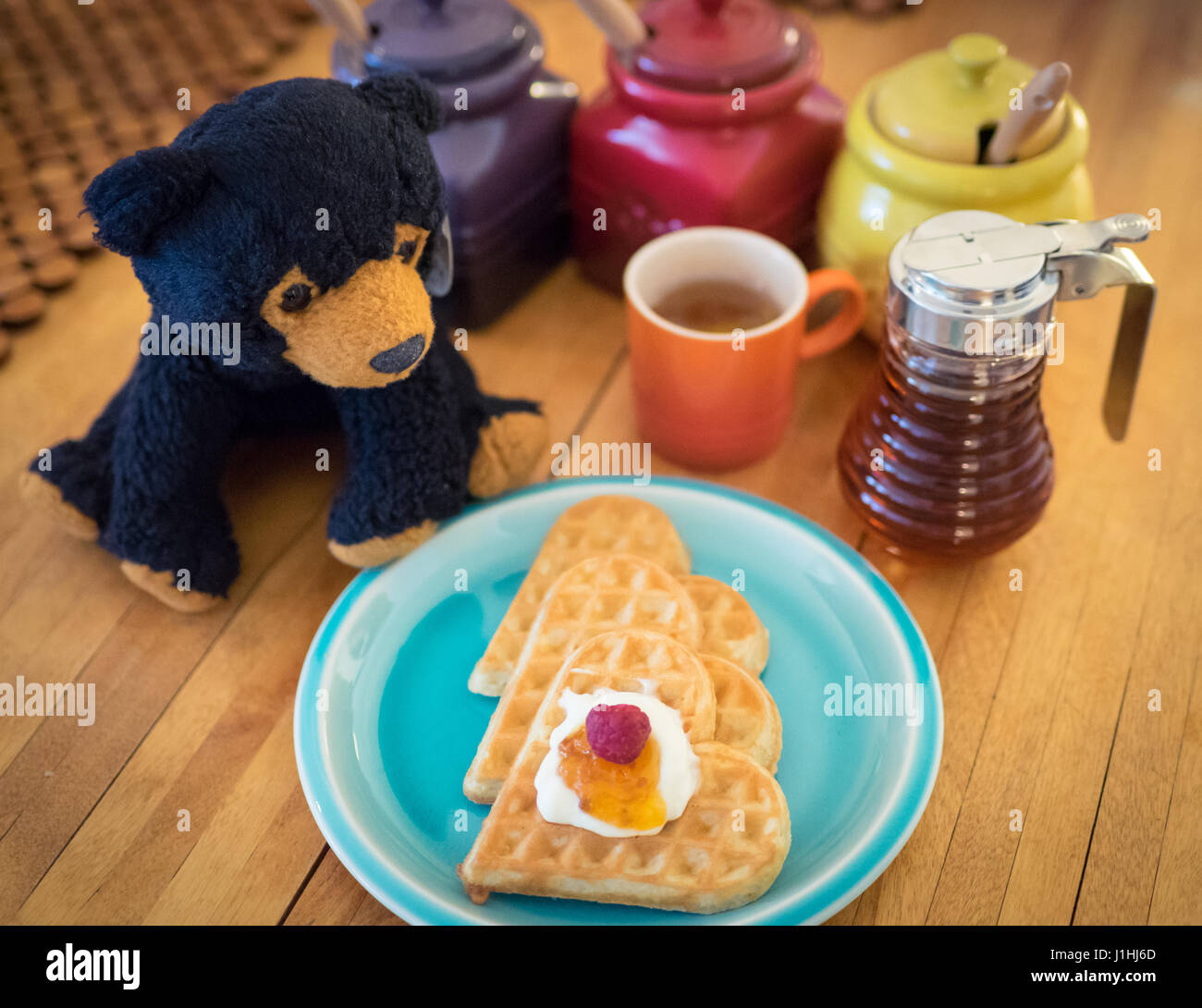 Schwedische herzförmigen Waffeln (garniert mit Schlagsahne und Moltebeeren Marmelade) auf Våffedagen (schwedische Waffel-Tag), März 25. Stockfoto