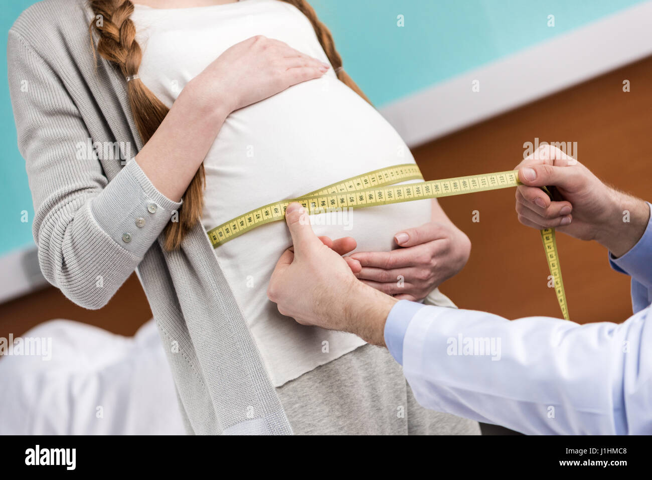 Schuss des Arztes, die Messung der Bauch der schwangeren Frau im Krankenhaus beschnitten Stockfoto