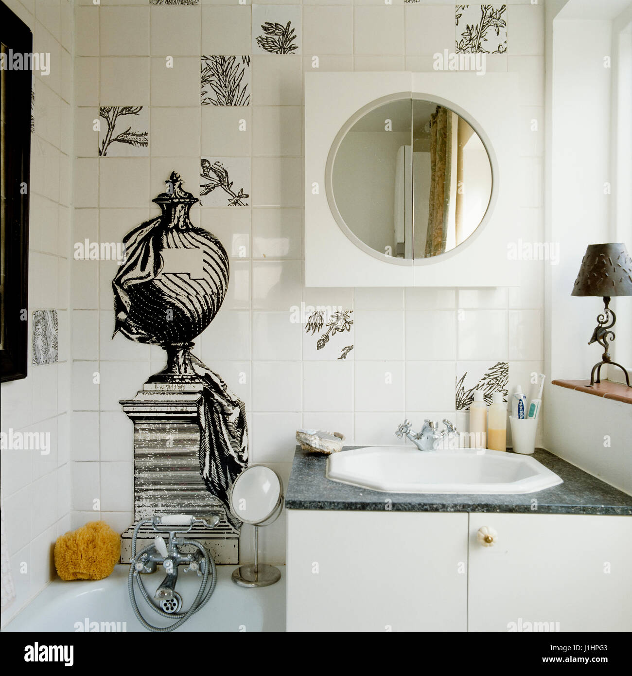 Badezimmer mit Abbildungen auf gefliesten Wand. Stockfoto