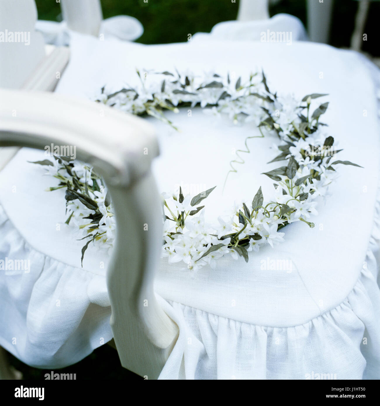 Kranz aus weißen Blüten auf Stuhl. Stockfoto