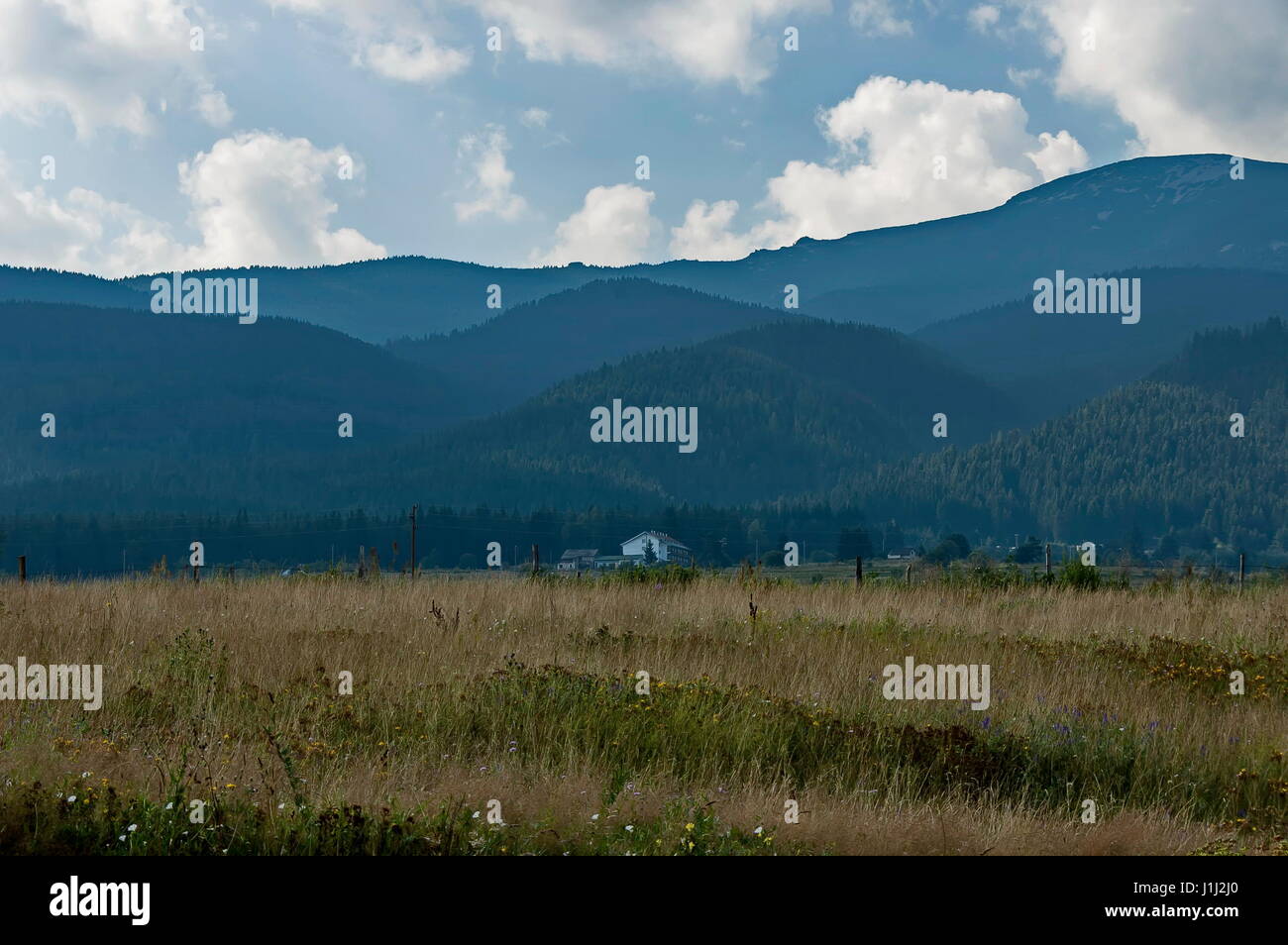 Majestätische Berggipfel, bewachsen mit Nadelwald, Tal, Lichtung und Haus, Rila-Gebirge, Bulgarien Stockfoto